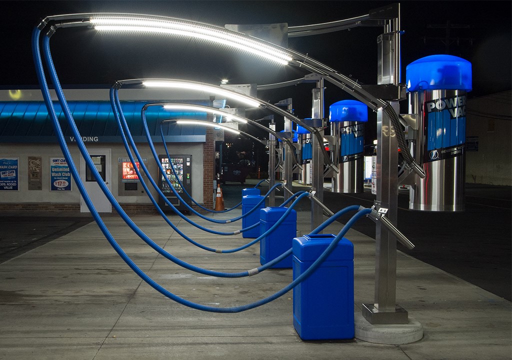 Modern blue and chrome carwash arch systems lit at night