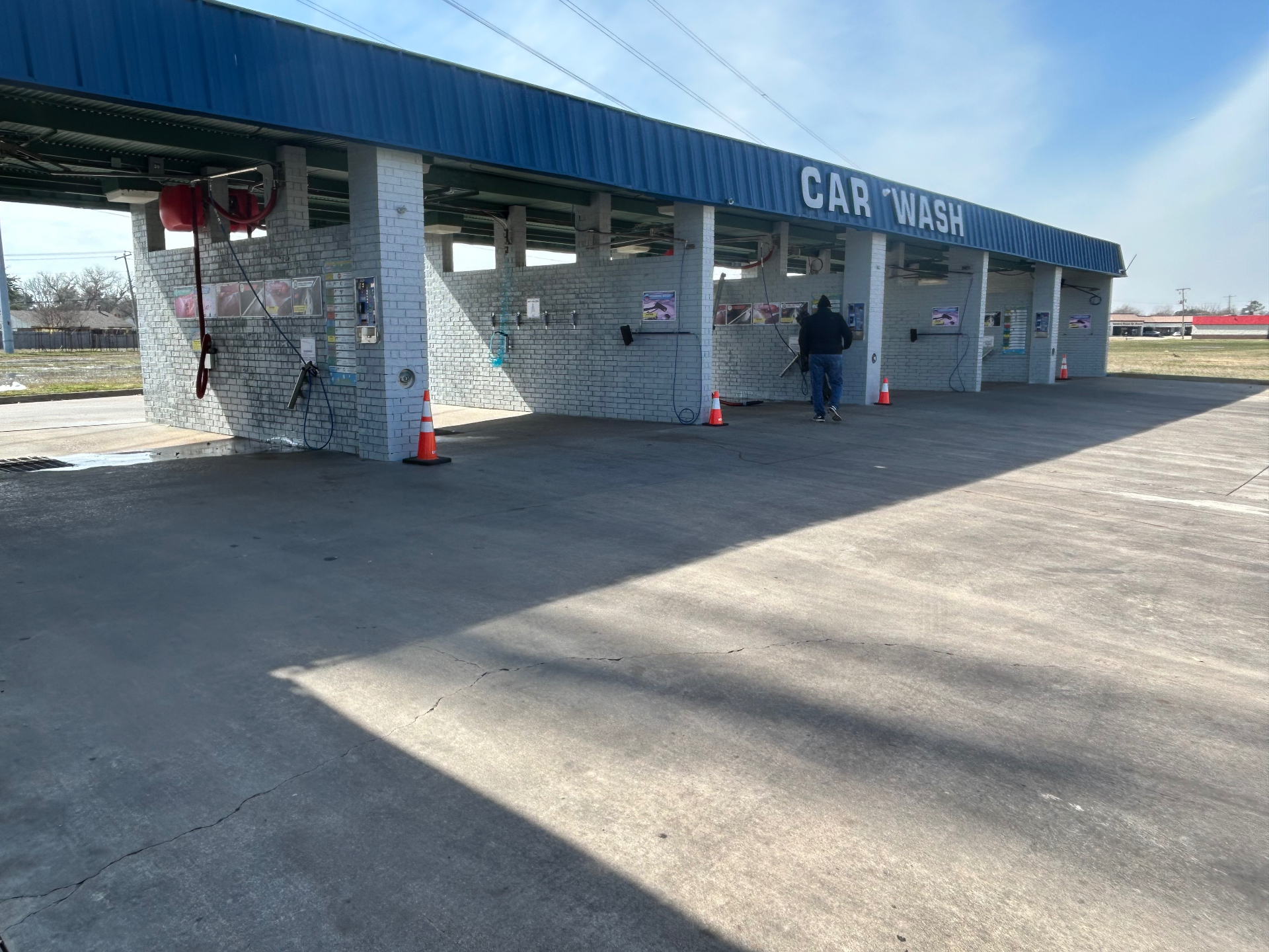 Recently serviced self-serve carwash bays with wash controls and hoses