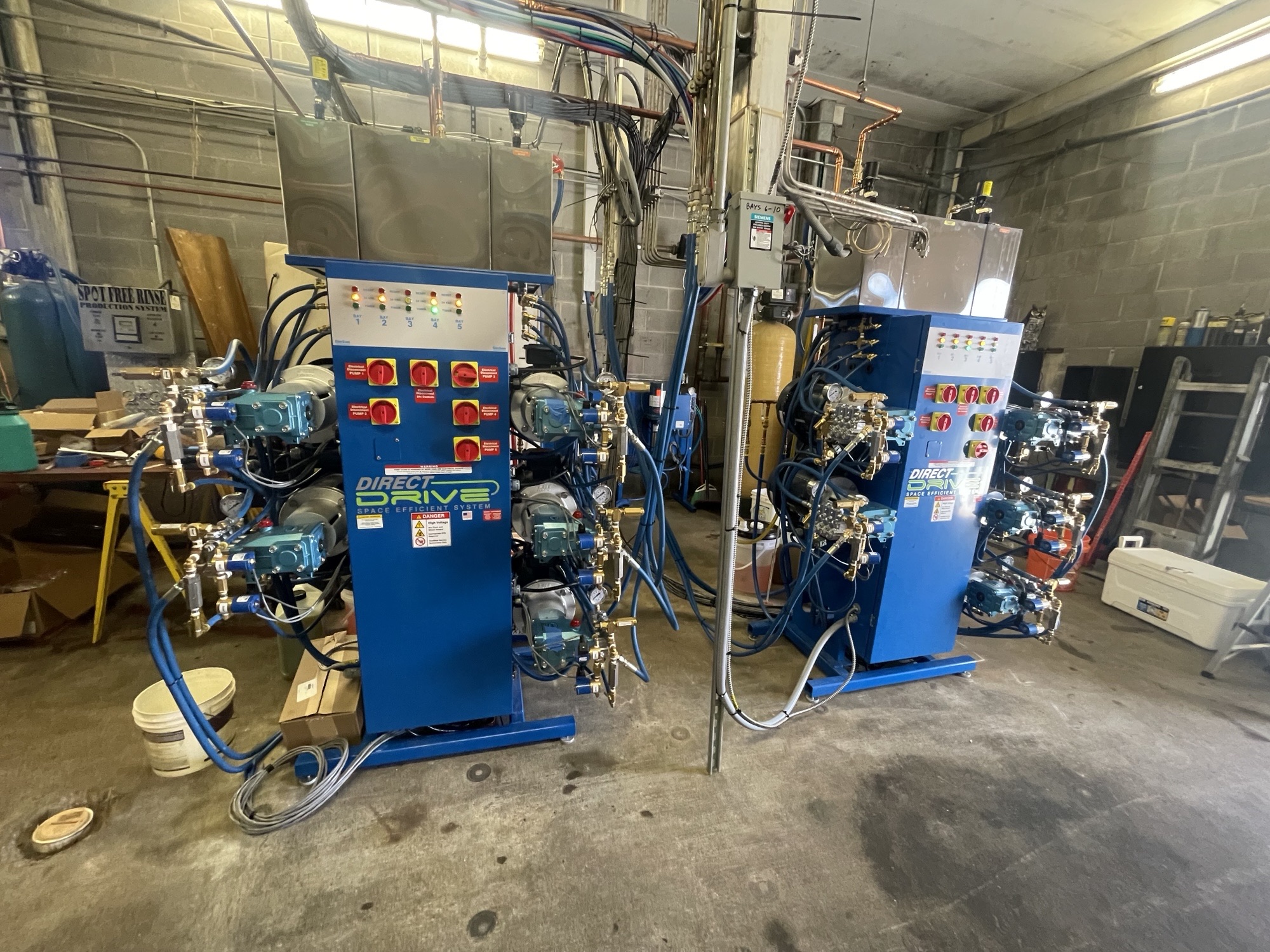 Two blue Direct Drive carwash equipment systems installed in a utility room