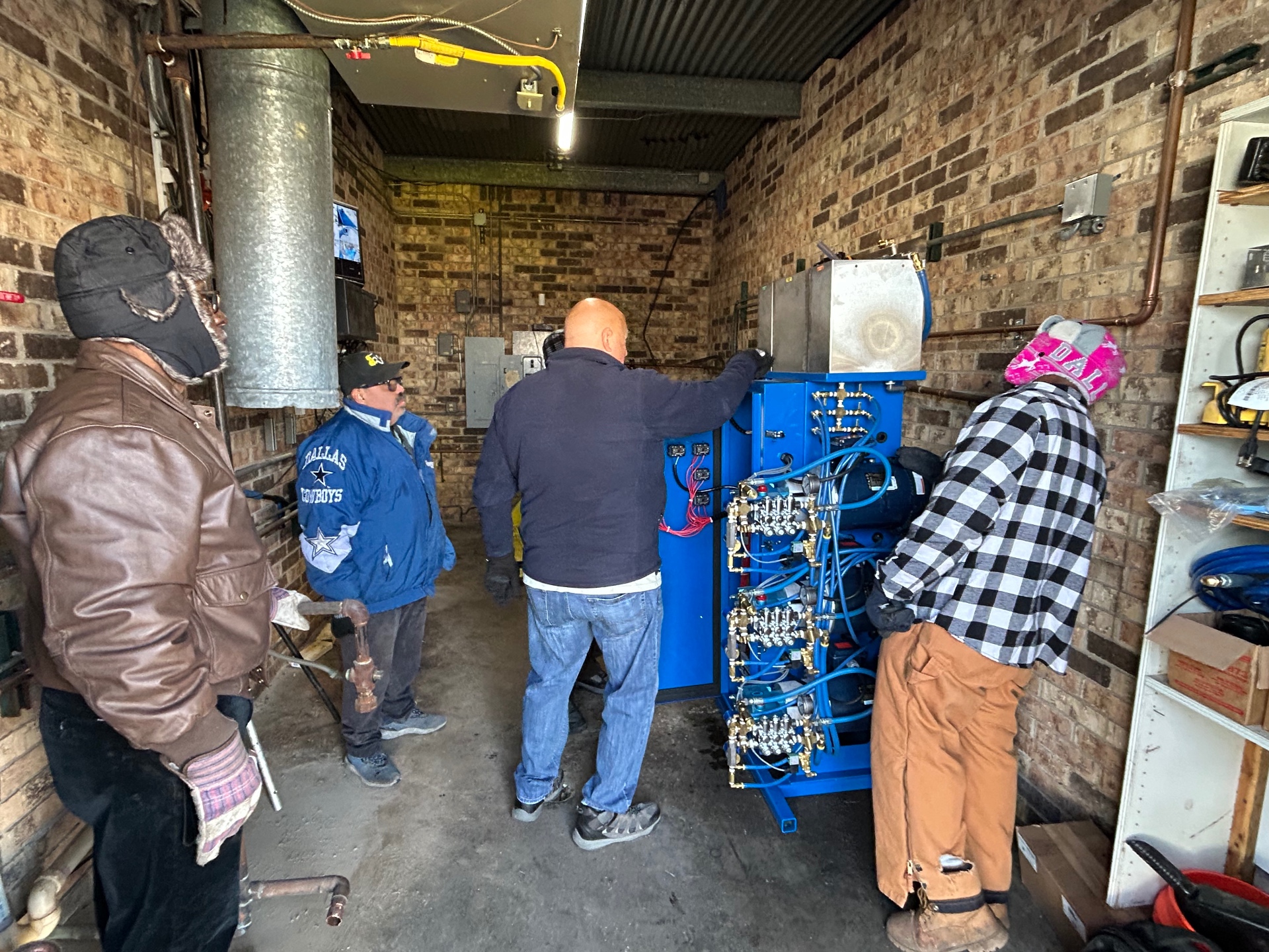 Technicians working around blue carwash equipment during a recent job