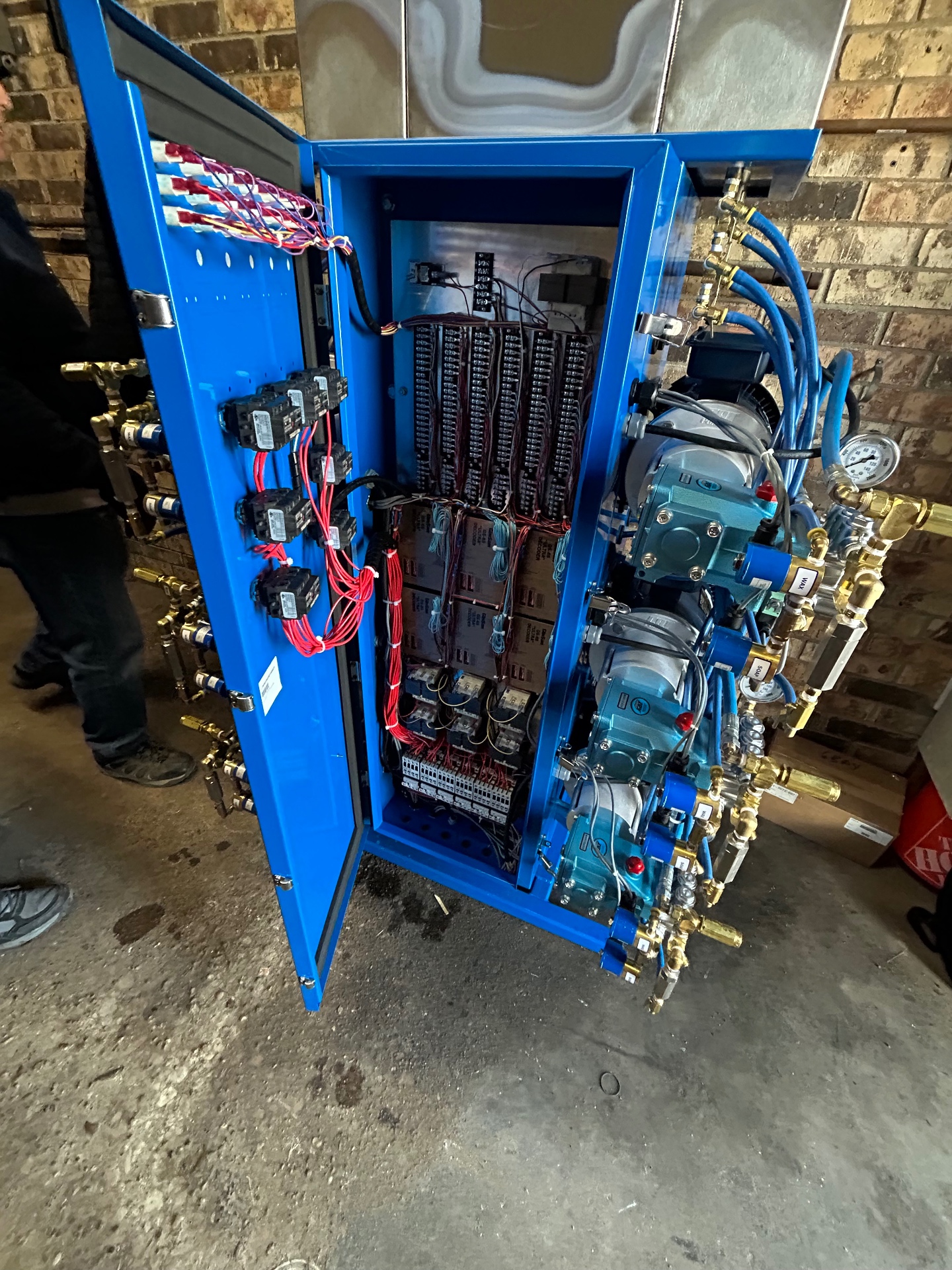 Open blue meterbox cabinet showing protected wiring, pumps, and controls