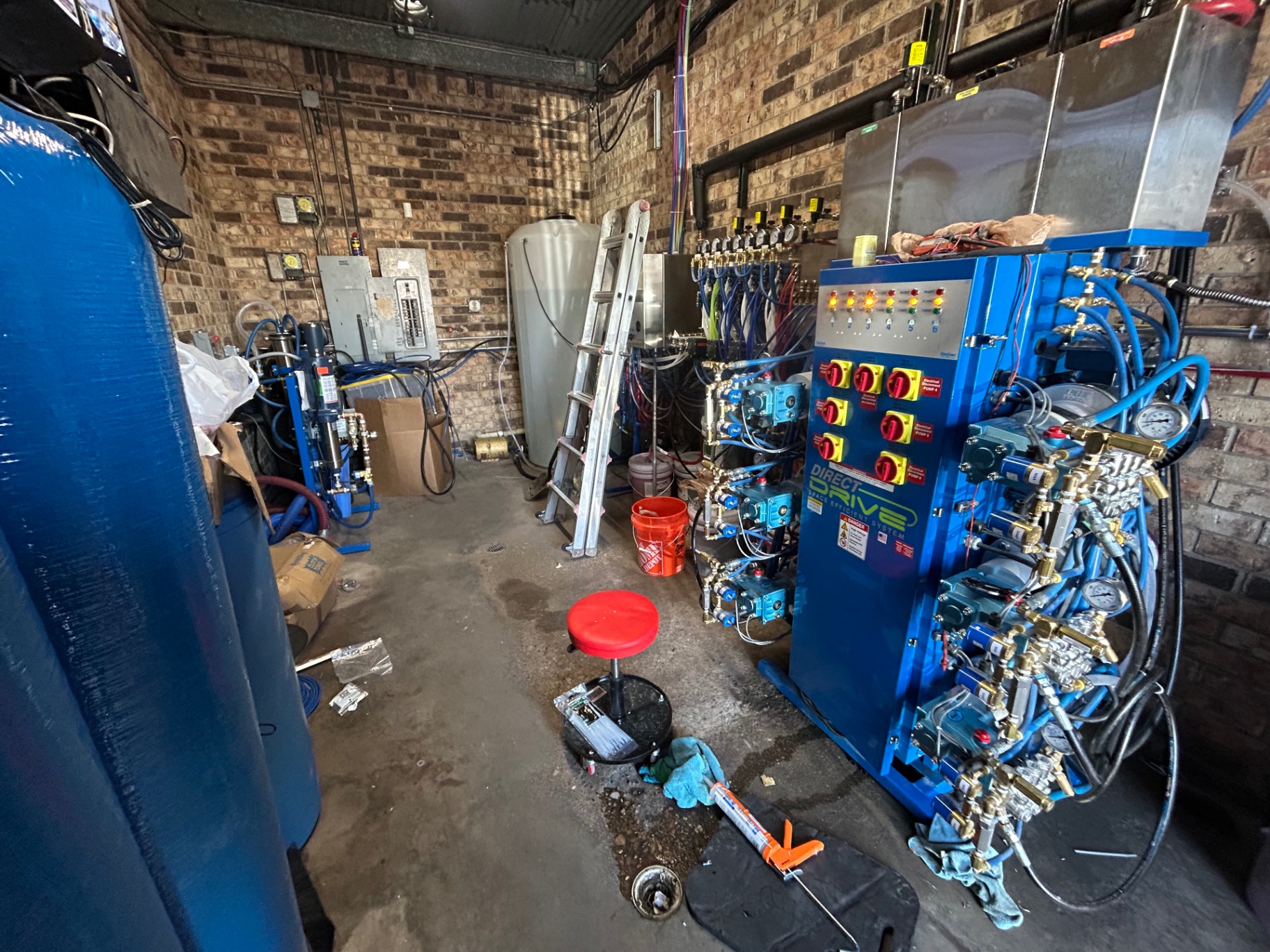 Blue carwash equipment and meterbox system installed inside a brick equipment room